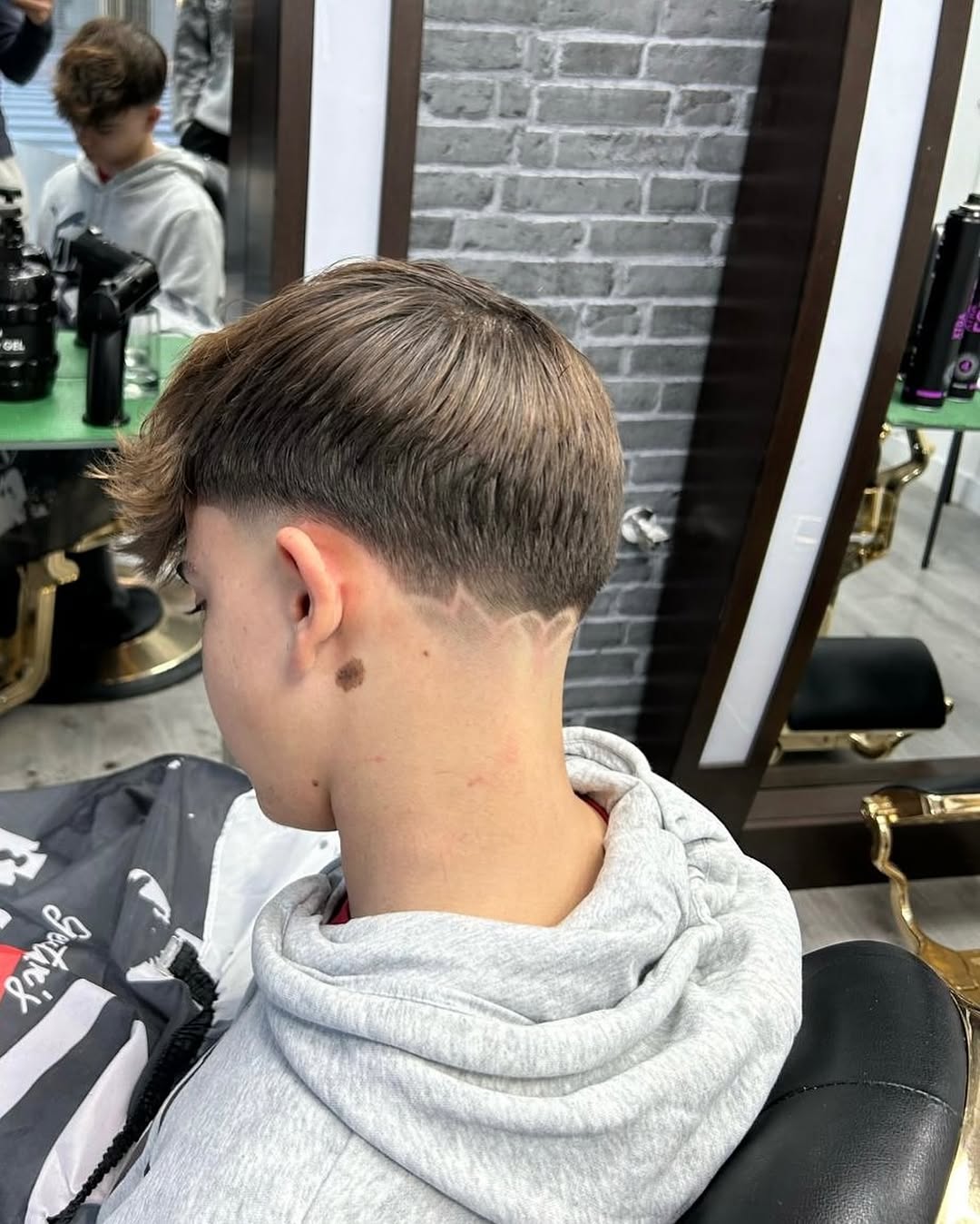 Corte juvenil con degradado y detalle rasurado en la nuca