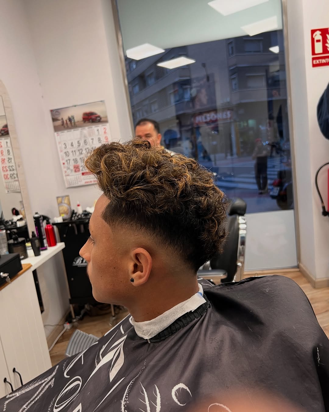 Rizos con mechas y degradado alto